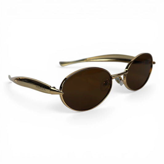 The Aveline oval sunglasses in gold with brown lenses, angled three-quarter view