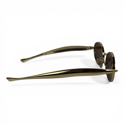 The Aveline oval sunglasses in gold with brown lenses, side profile view