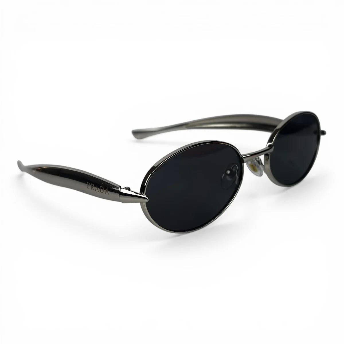 The Aveline oval sunglasses in silver with black lenses, angled three-quarter view
